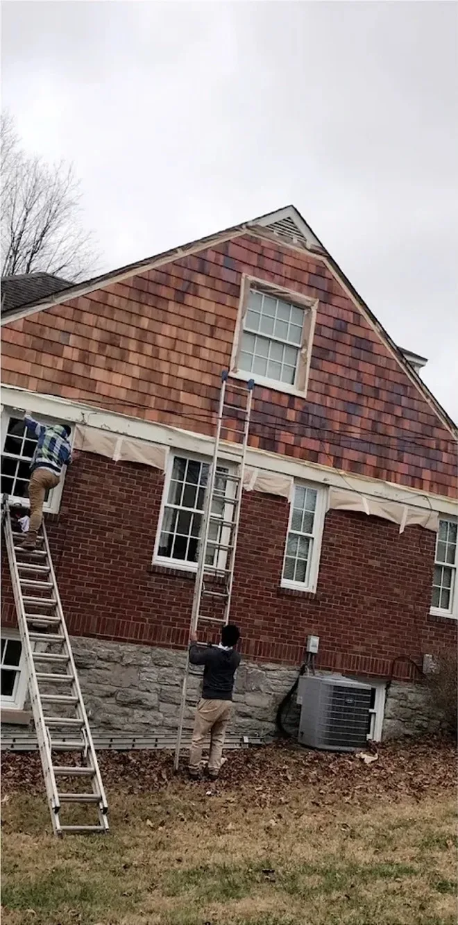 Towers crew on ladders painting cedar shake siding in Middle Tennessee
